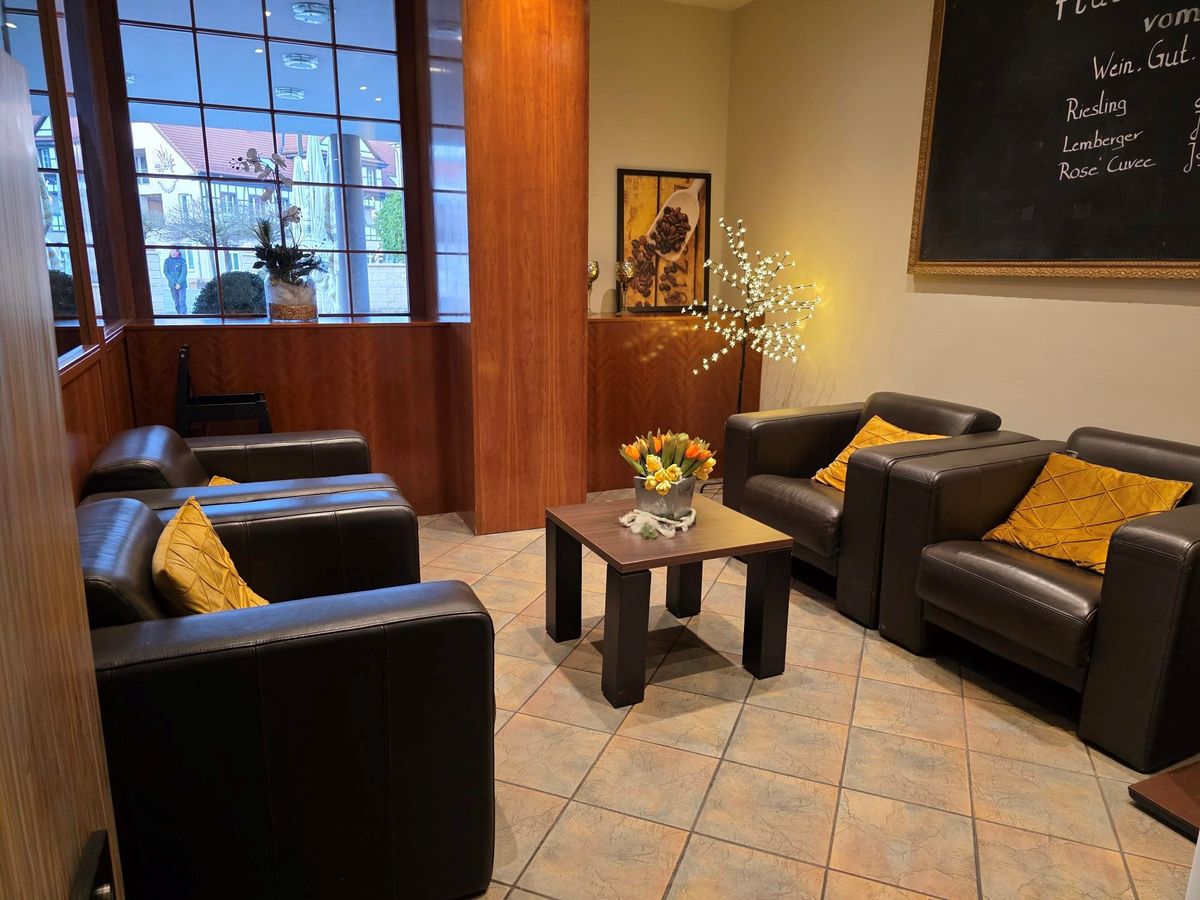 Gemütliche Lounge-Ecke des Hotels SONNE-POST mit Ledersesseln und goldenen Akzentkissen